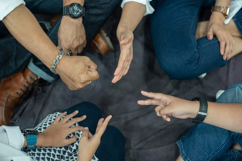 A group of people play rock, paper, scissors